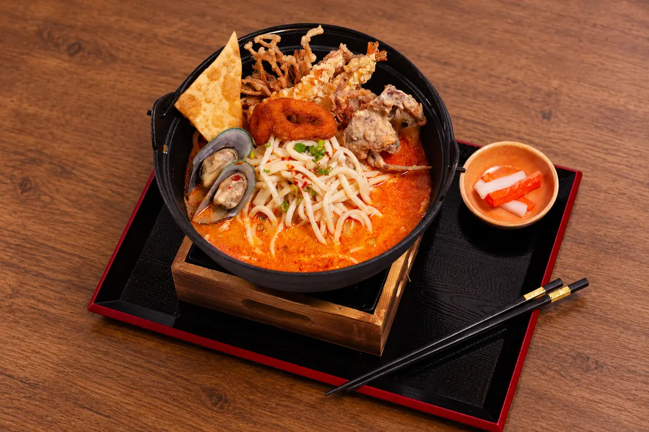 Royal Tom Yum Seafood with udon, mussels, and crispy seafood.